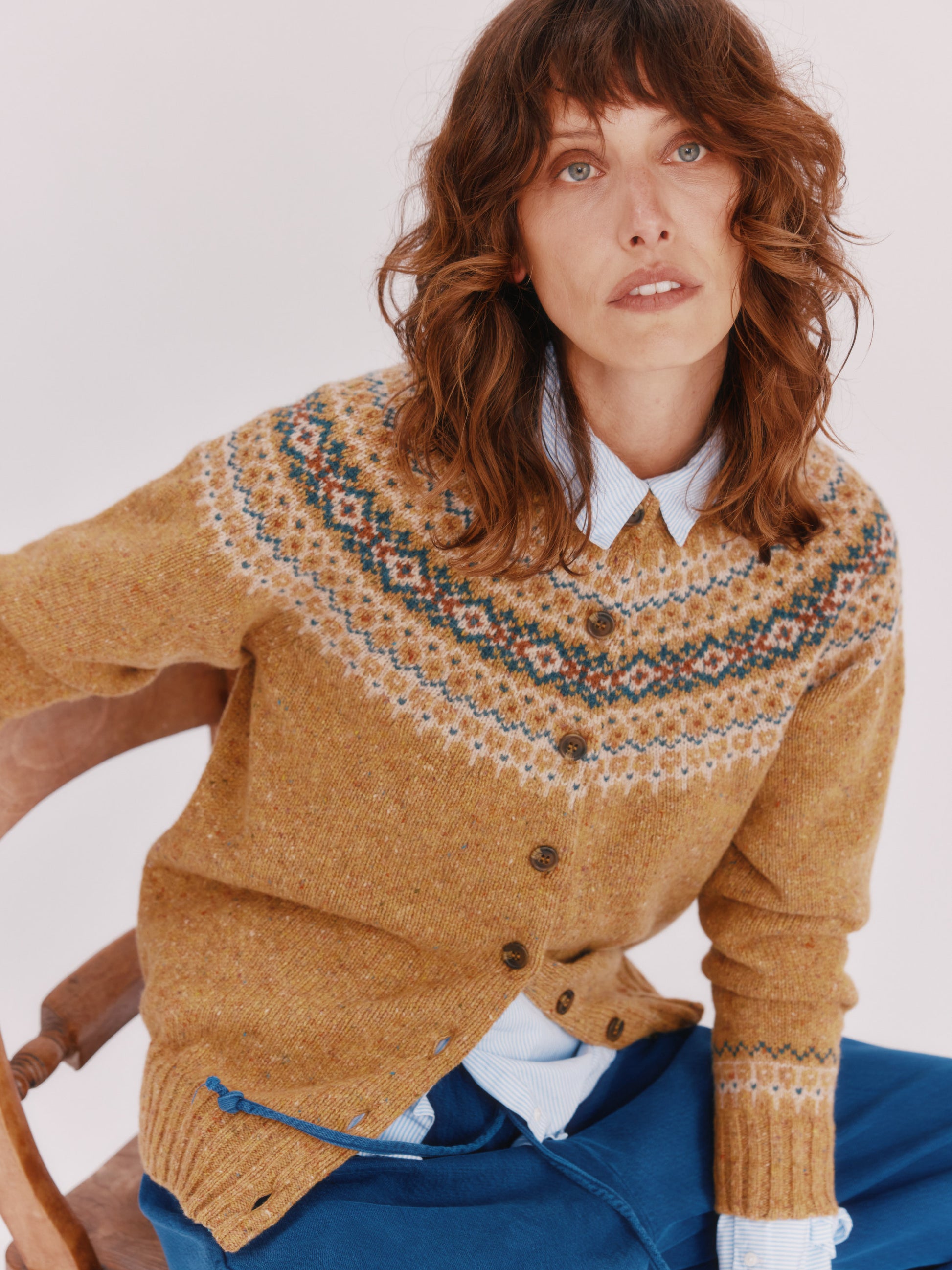 Model wearing a Bosie Knitwear Islander Yoke Fair Isle Glenugie Women's Cardigan in colour Barra Gold.