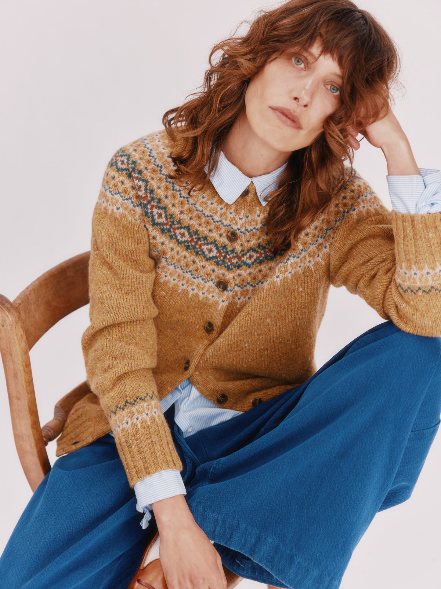 Model wearing a Bosie Knitwear Islander Yoke Fair Isle Glenugie Women's Cardigan in colour Barra Gold.