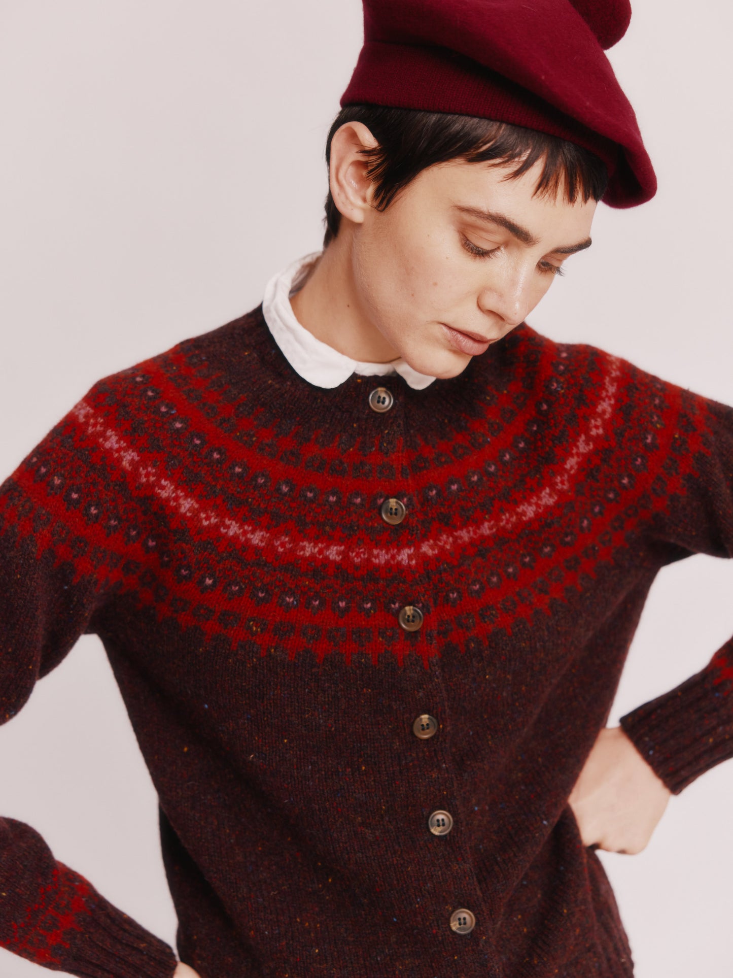 Model wearing a Bosie Knitwear Islander Yoke Fair Isle Glenugie Women's Cardigan in colour Lewis Dark Aubergine.