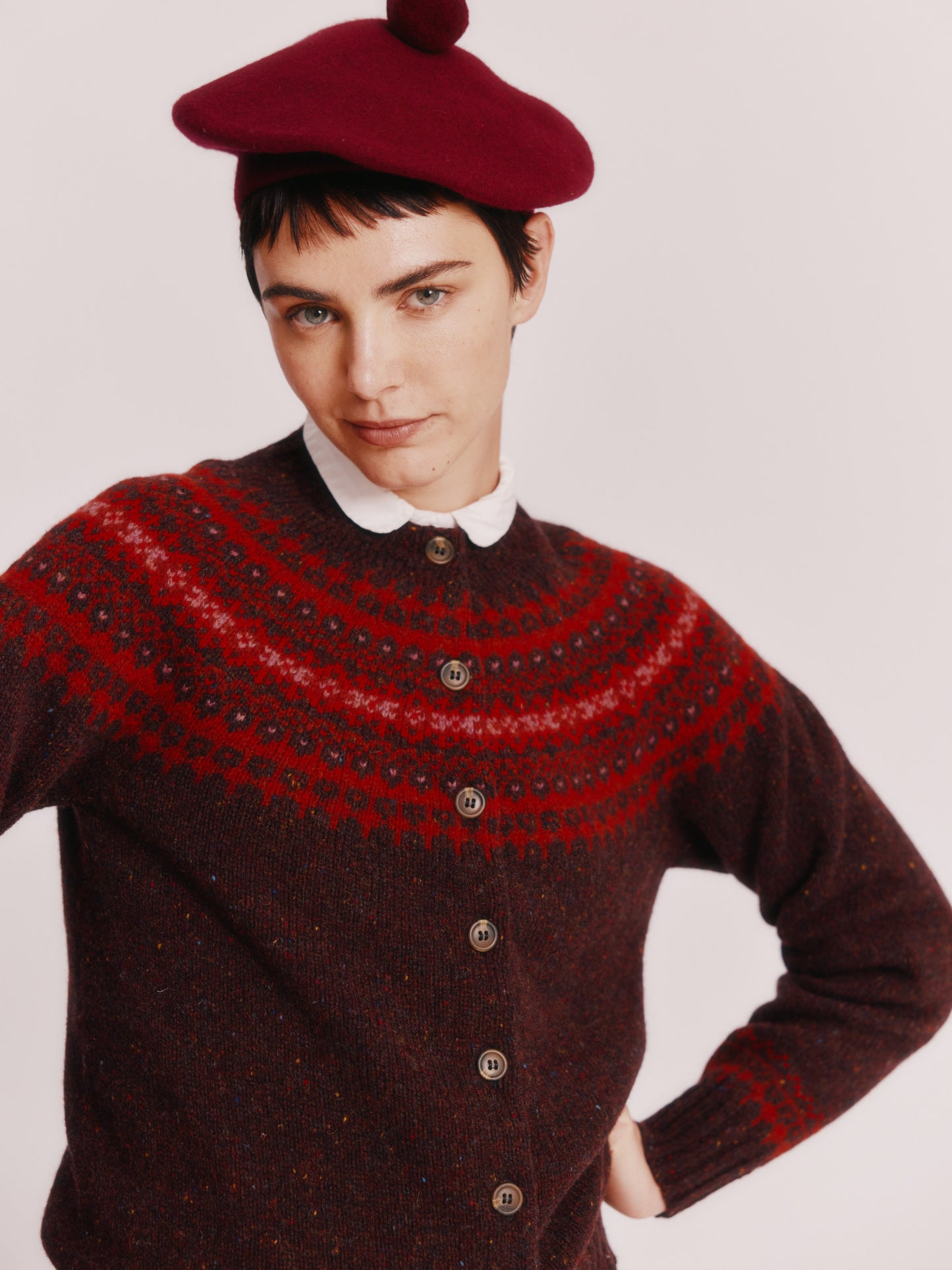Model wearing a Bosie Knitwear Islander Yoke Fair Isle Glenugie Women's Cardigan in colour Lewis Dark Aubergine.