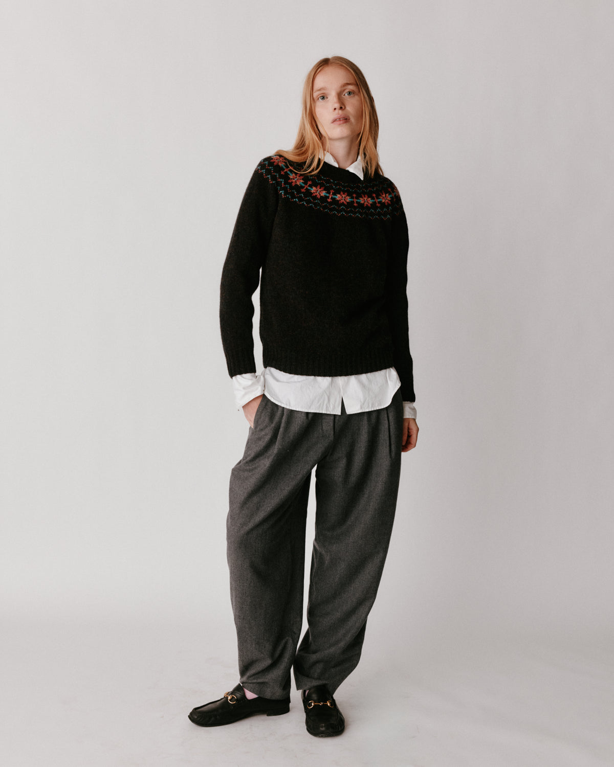 A model wearing a Bosie Murron Yoke Fair Isle Women's Sweater in colour Volcano/Midnight.