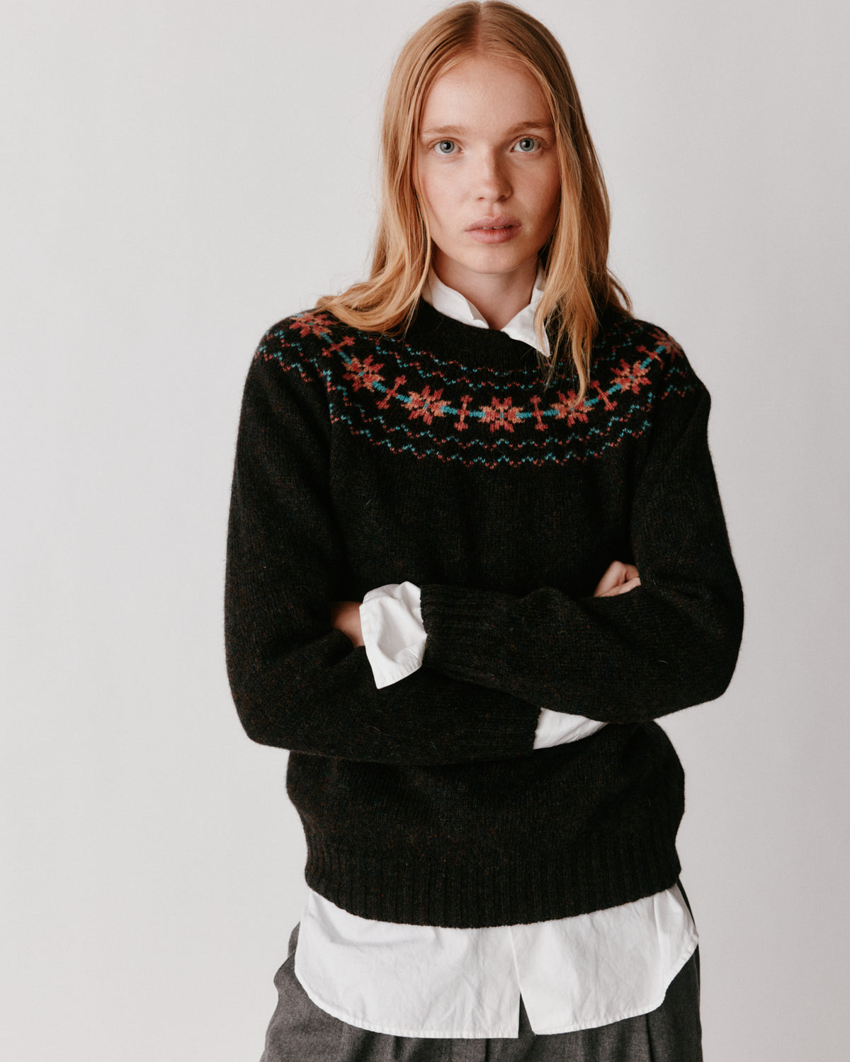 A model wearing a Bosie Murron Yoke Fair Isle Women's Sweater in colour Volcano/Midnight.