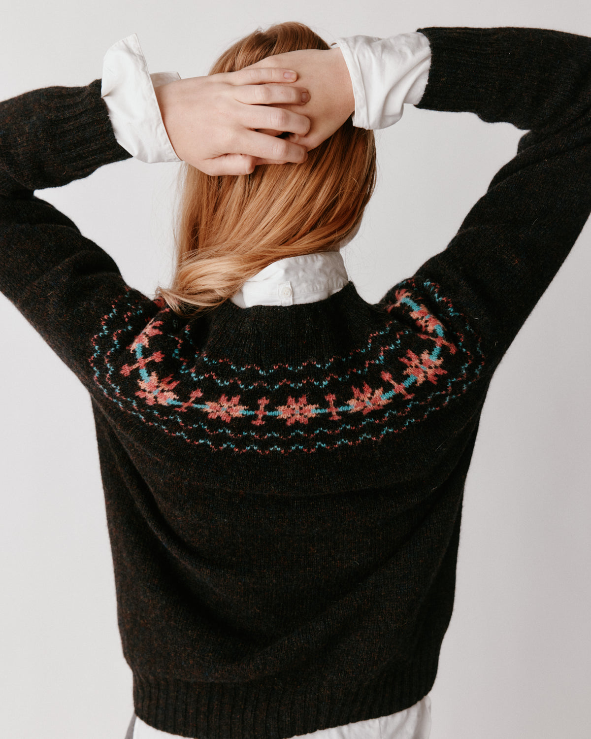 A model wearing a Bosie Murron Yoke Fair Isle Women's Sweater in colour Volcano/Midnight.