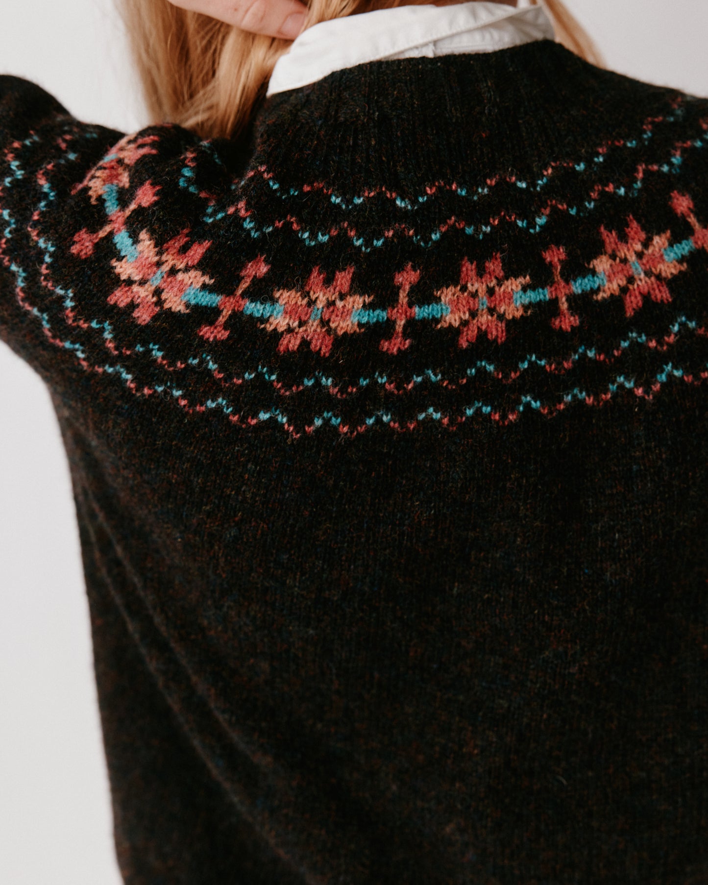 A model wearing a Bosie Murron Yoke Fair Isle Women's Sweater in colour Volcano/Midnight.