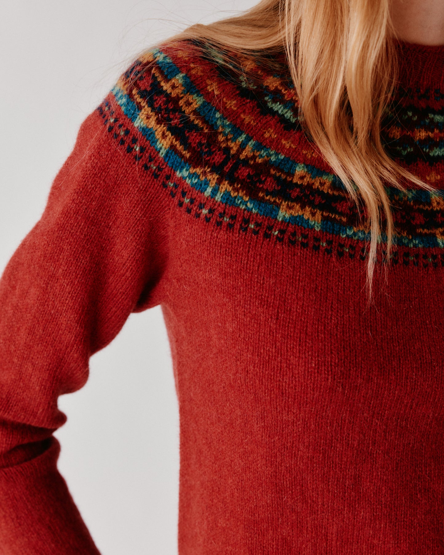 A model wearing a Bosie Skye Yoke Fair Isle Women's Sweater in colour Framboise.