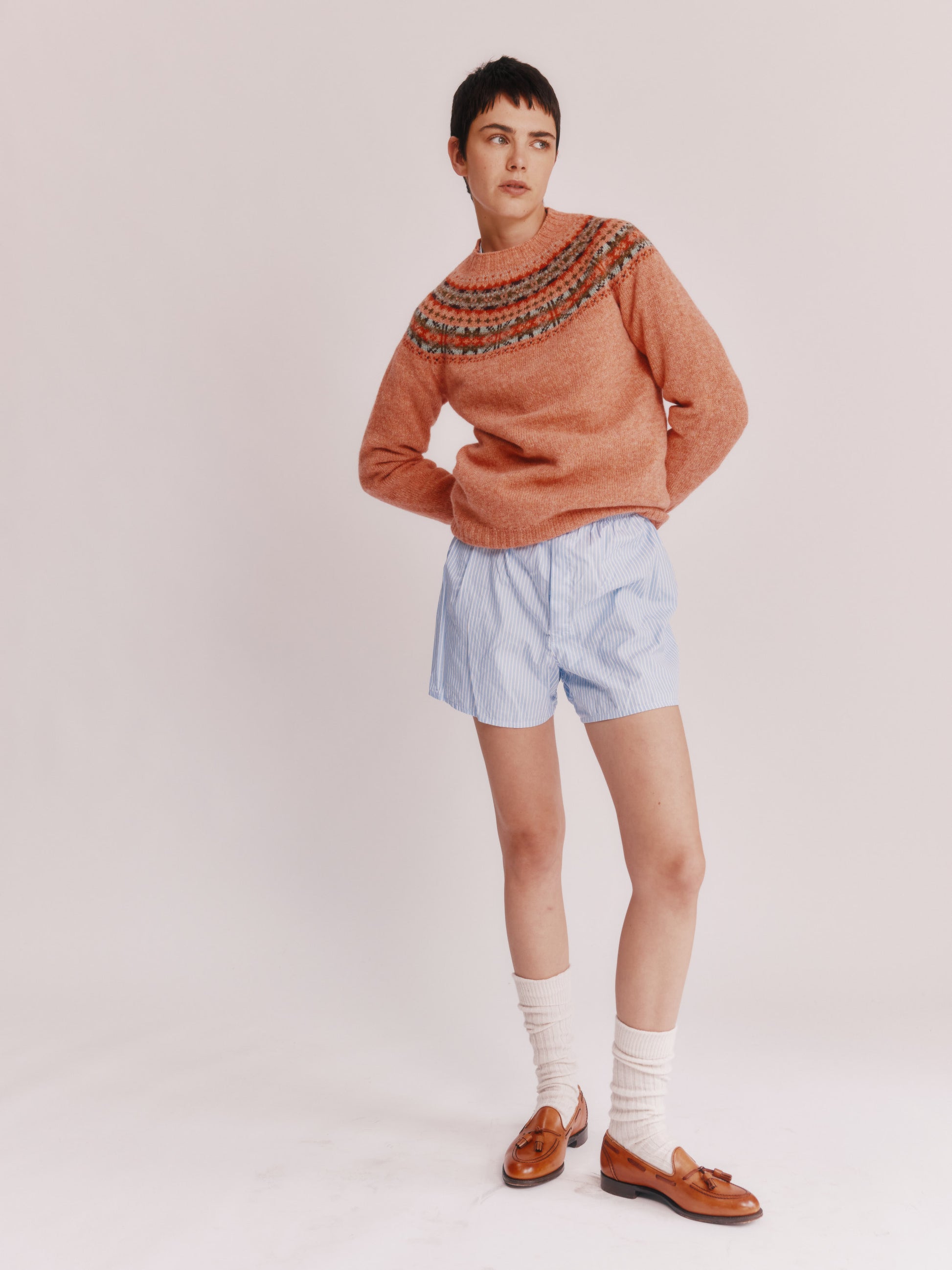 Model wearing a Skye Yoke Fair Isle Women's Sweater  in colour Parfait Peach. 