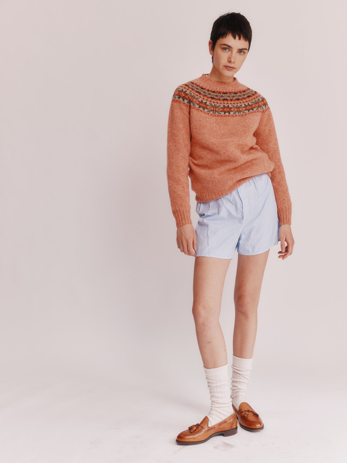 Model wearing a Skye Yoke Fair Isle Women's Sweater  in colour Parfait Peach. 