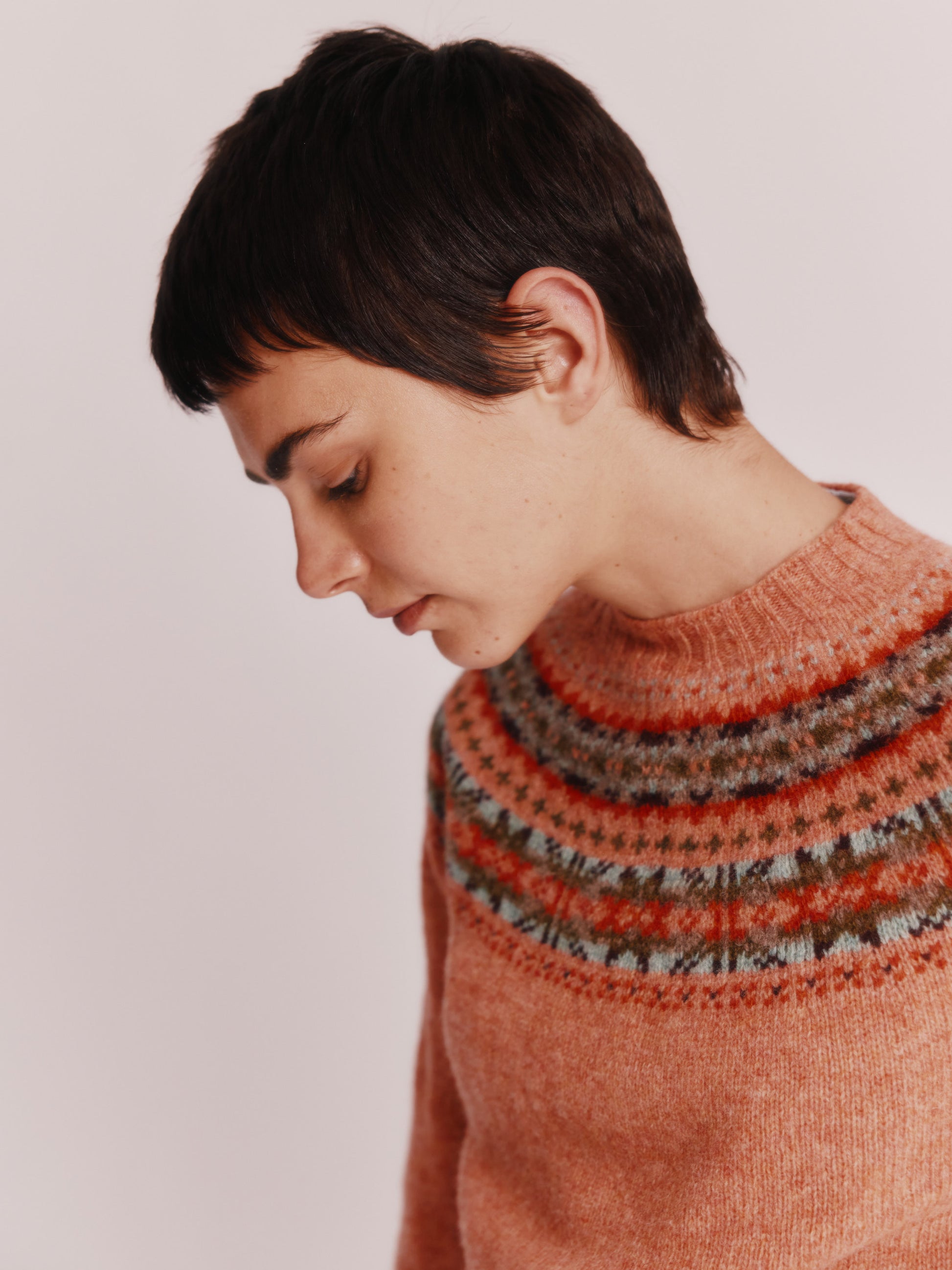 Model wearing a Skye Yoke Fair Isle Women's Sweater  in colour Parfait Peach. 