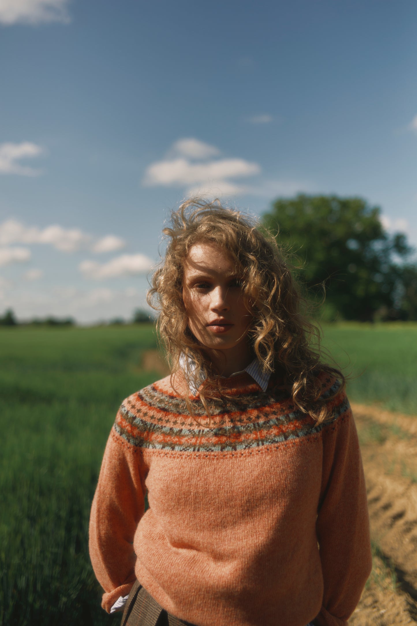 Model wearing a Skye Yoke Fair Isle Women's Sweater  in colour Parfait Peach. 