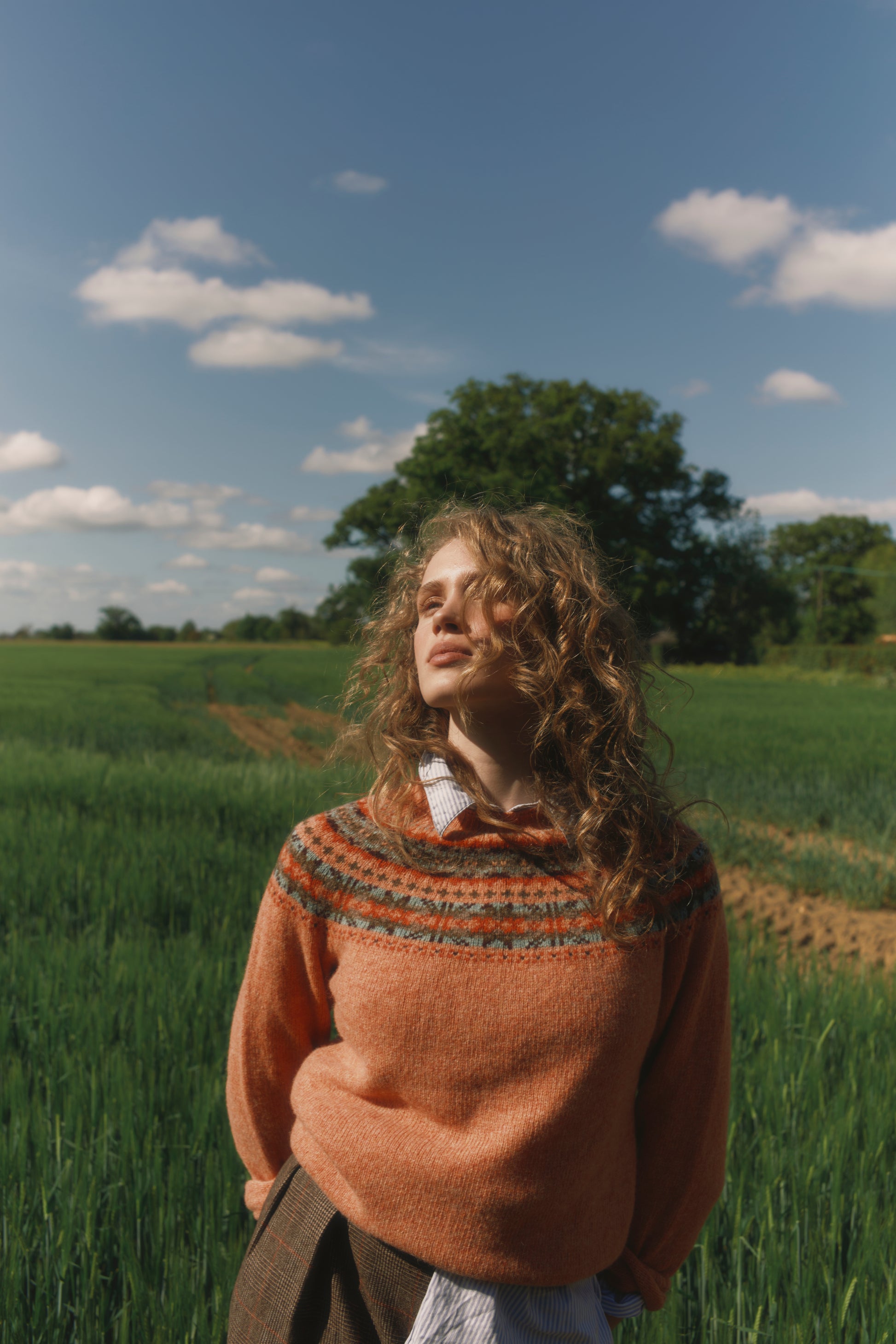 Model wearing a Skye Yoke Fair Isle Women's Sweater  in colour Parfait Peach. 