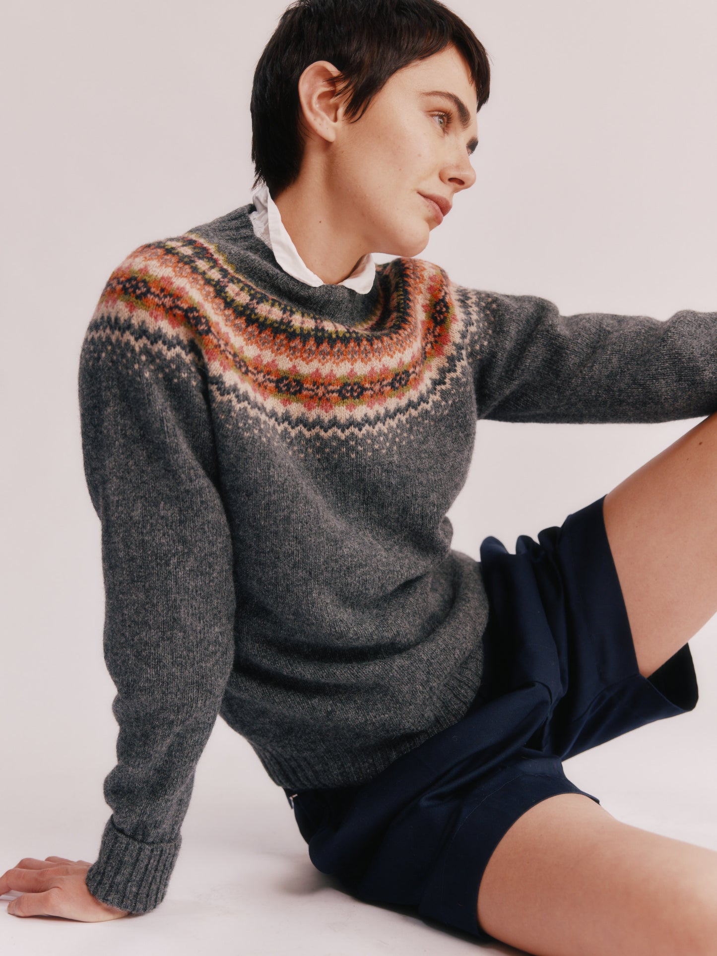Model wearing a Bosie Knitwear West Coast Yoke Fair Isle Women's Sweater in colour Oxford Grey.