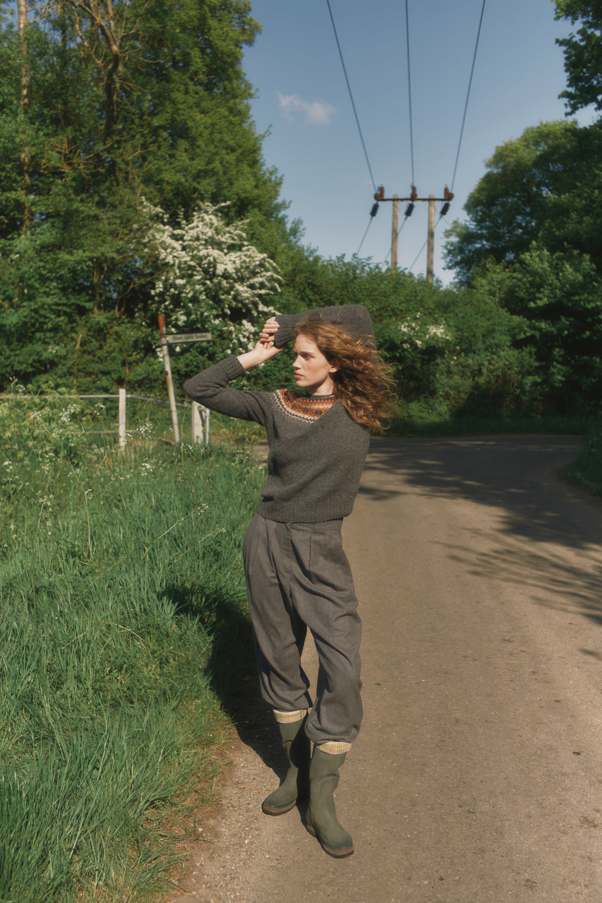 Model wearing a Bosie Knitwear West Coast Yoke Fair Isle Women's Sweater in colour Oxford Grey.