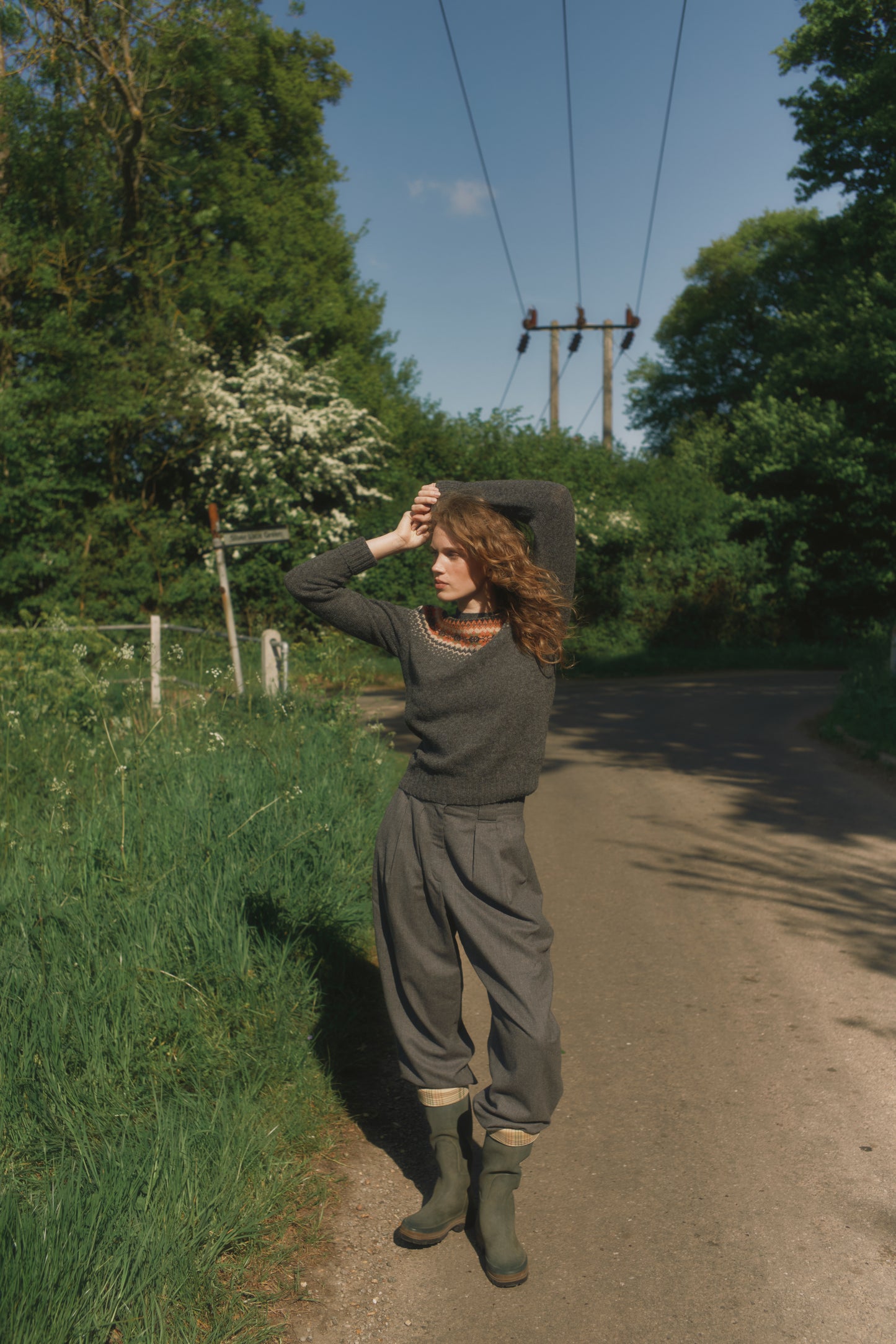Model wearing a Bosie Knitwear West Coast Yoke Fair Isle Women's Sweater in colour Oxford Grey.