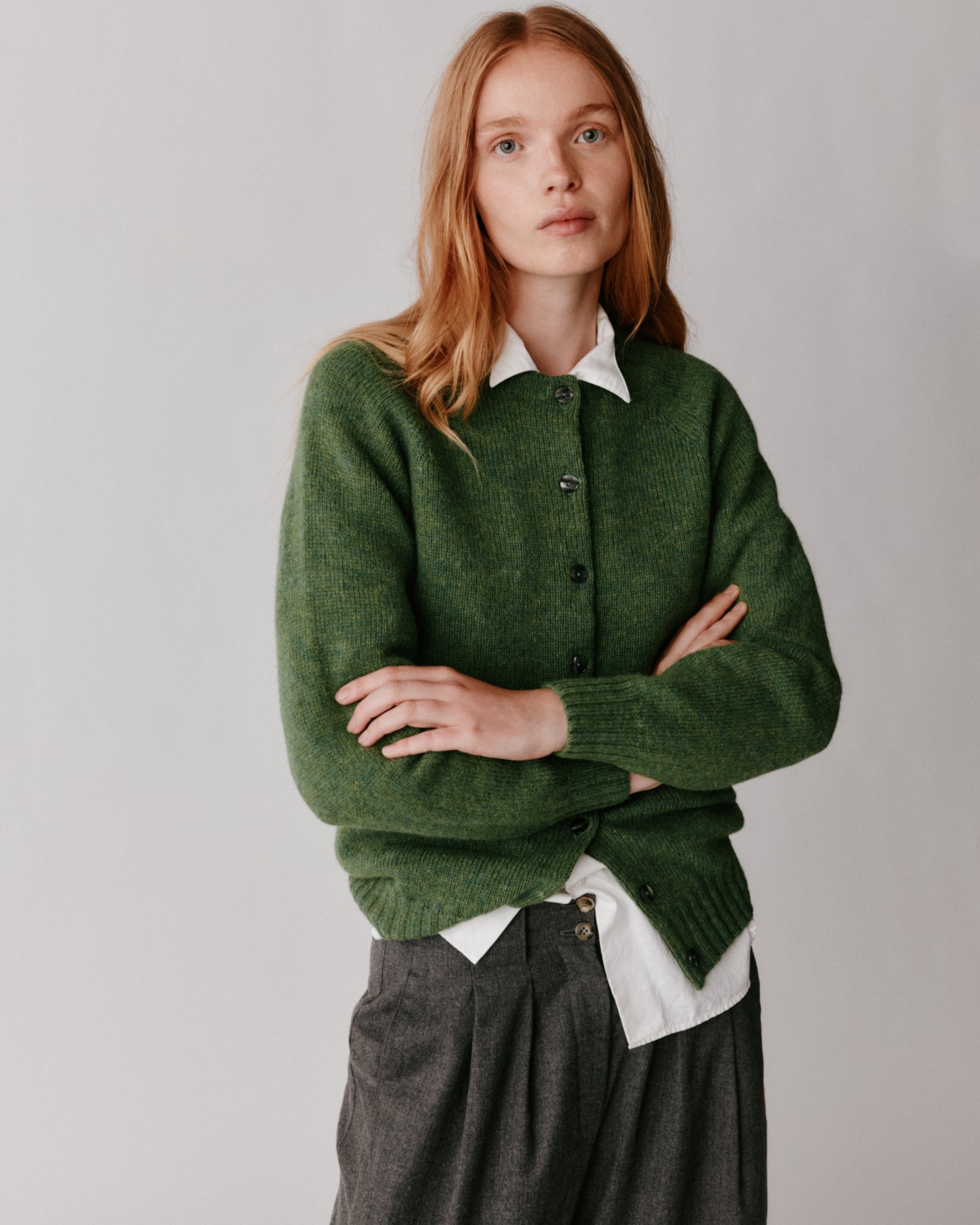 A model wearing a Bosie Womens Harley of Scotland Shetland Crew Neck Cardigan in colour Baize.