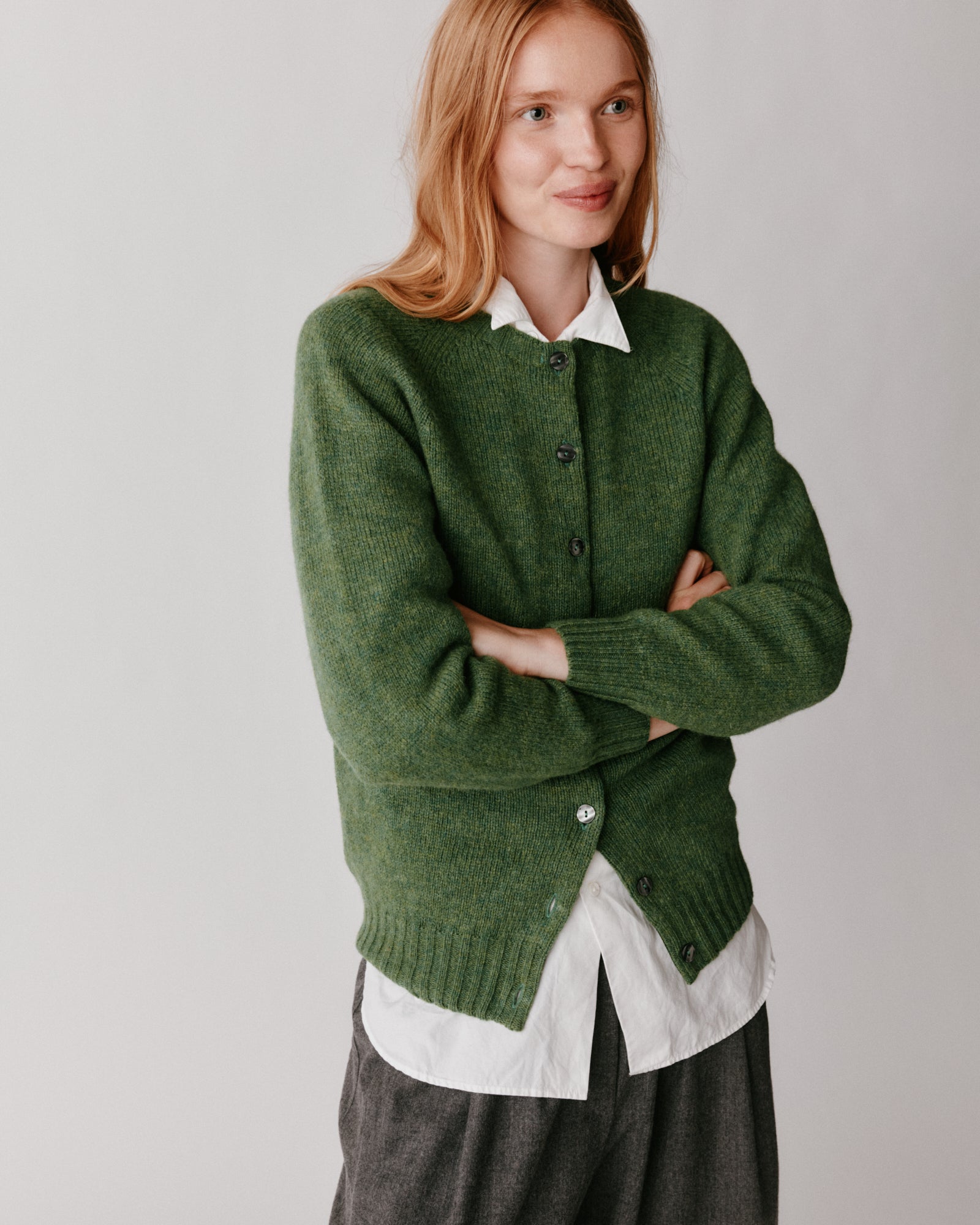 A model wearing a Bosie Womens Harley of Scotland Shetland Crew Neck Cardigan in colour Baize