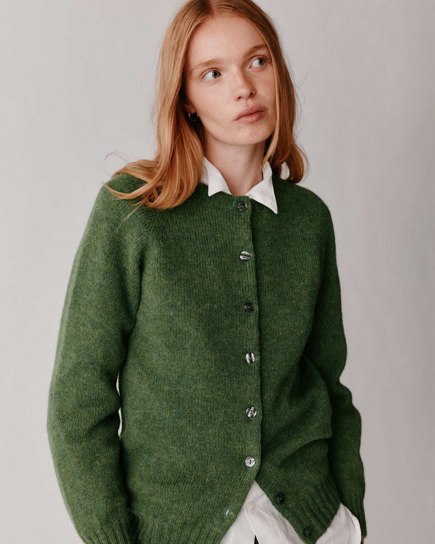 A model wearing a Bosie Womens Harley of Scotland Shetland Crew Neck Cardigan in colour Baize.