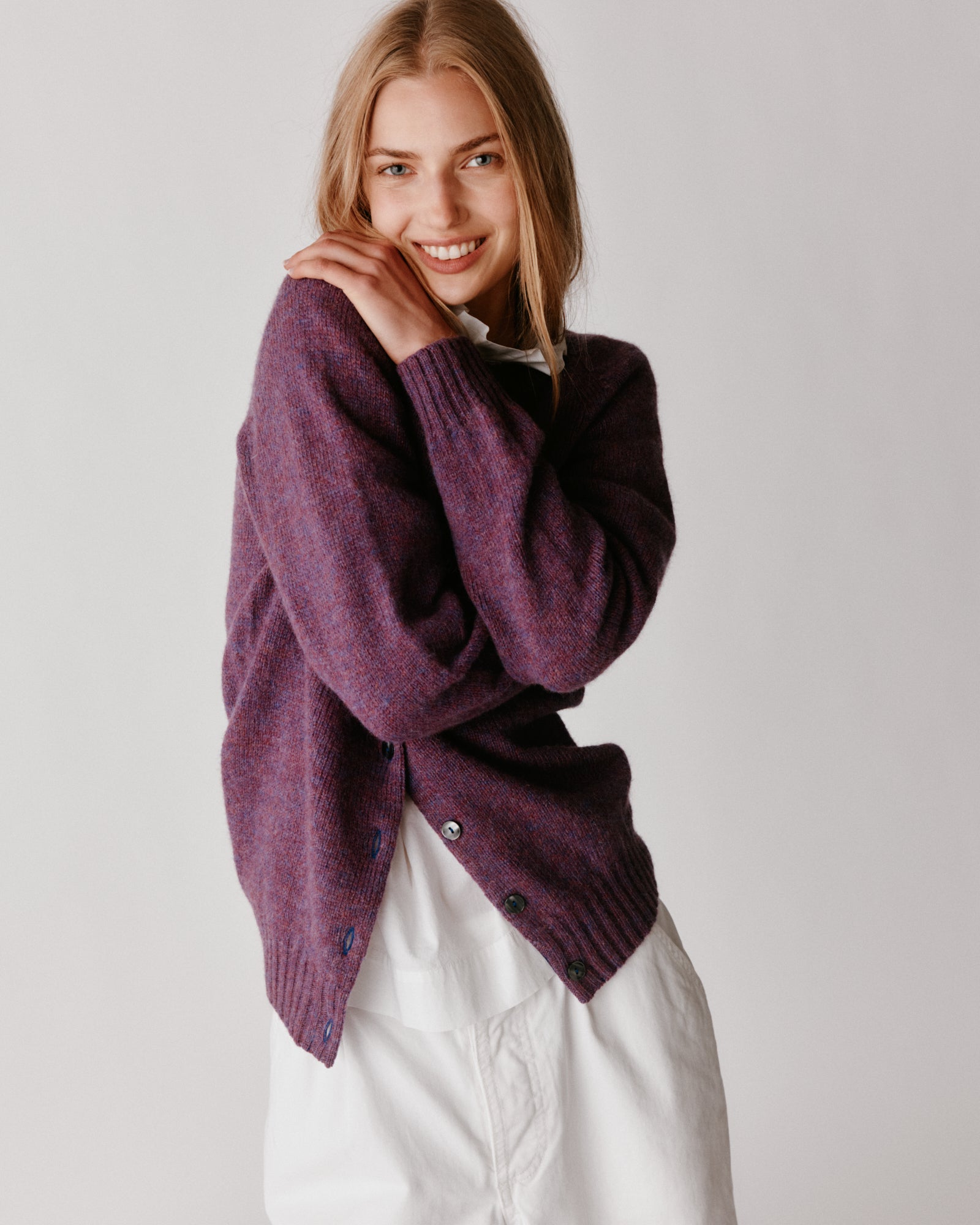 A model wearing a Bosie Womens Harley of Scotland Shetland Crew Neck Cardigan in colour Calluna.