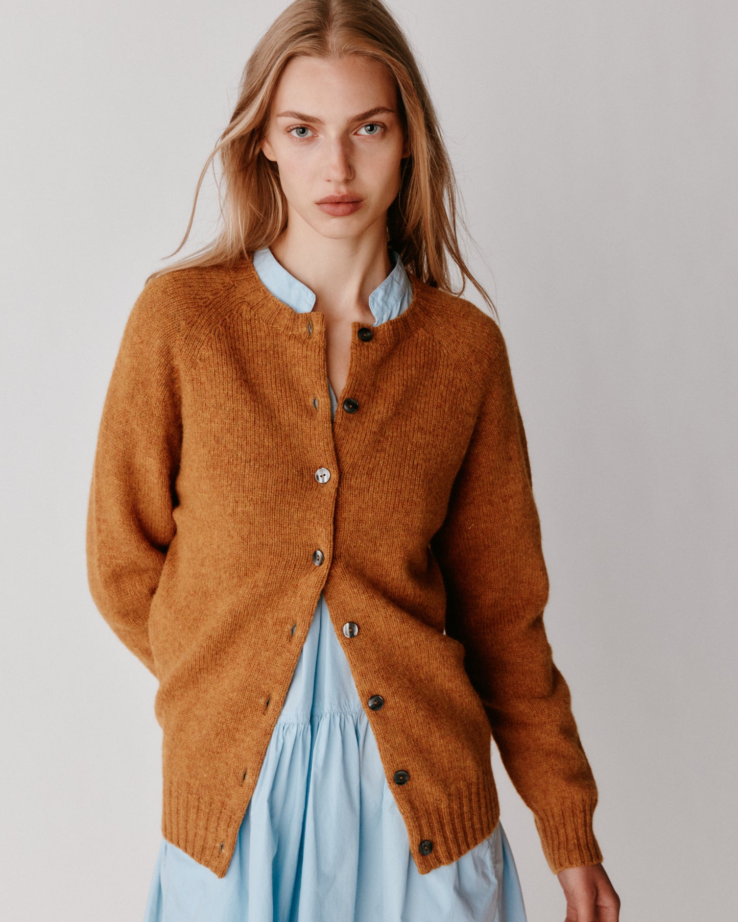 A model wearing a Bosie Womens Harley of Scotland Shetland Crew Neck Cardigan in colour Gold Dust / Cummin.