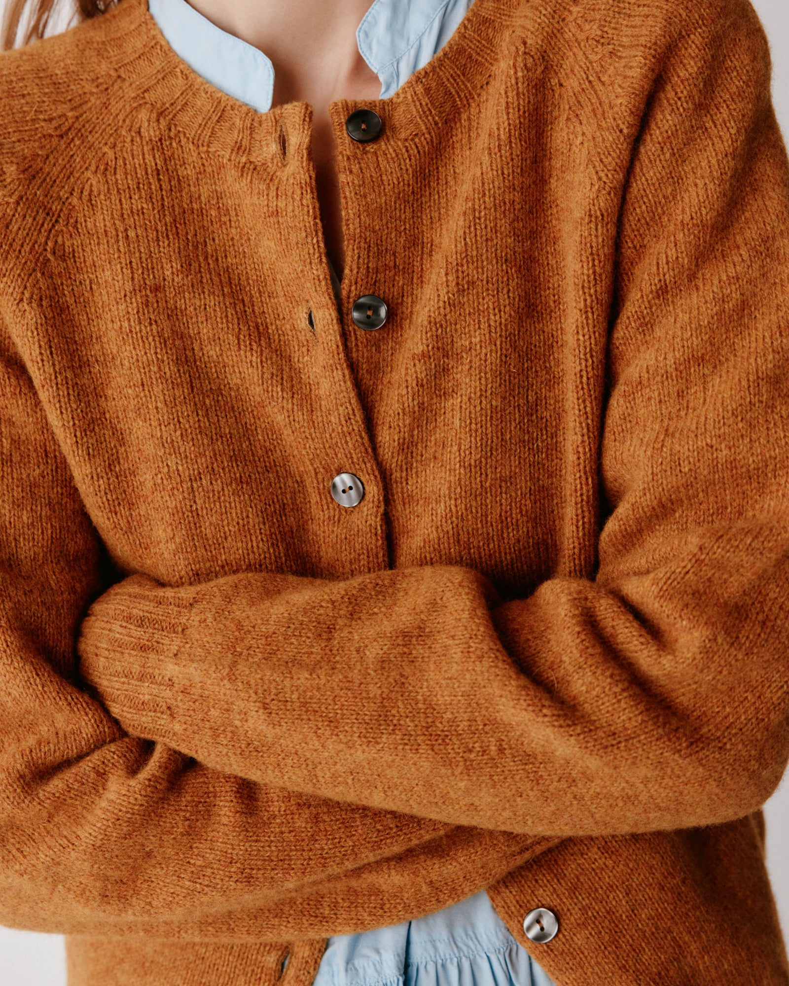 A model wearning a Bosie Womens Harley of Scotland Shetland Crew Neck Cardigan in colour Gold Dust / Cummin.