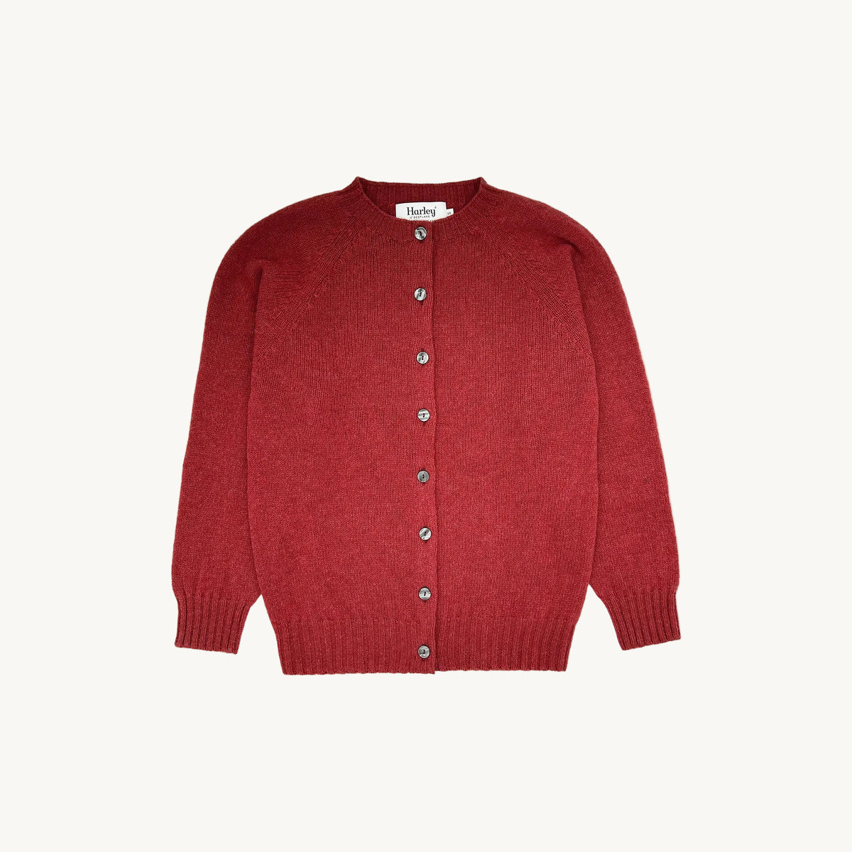A flatbed photograph of a Bosie Womens Harley of Scotland Shetland Crew Neck Cardigan in colour Framboise.