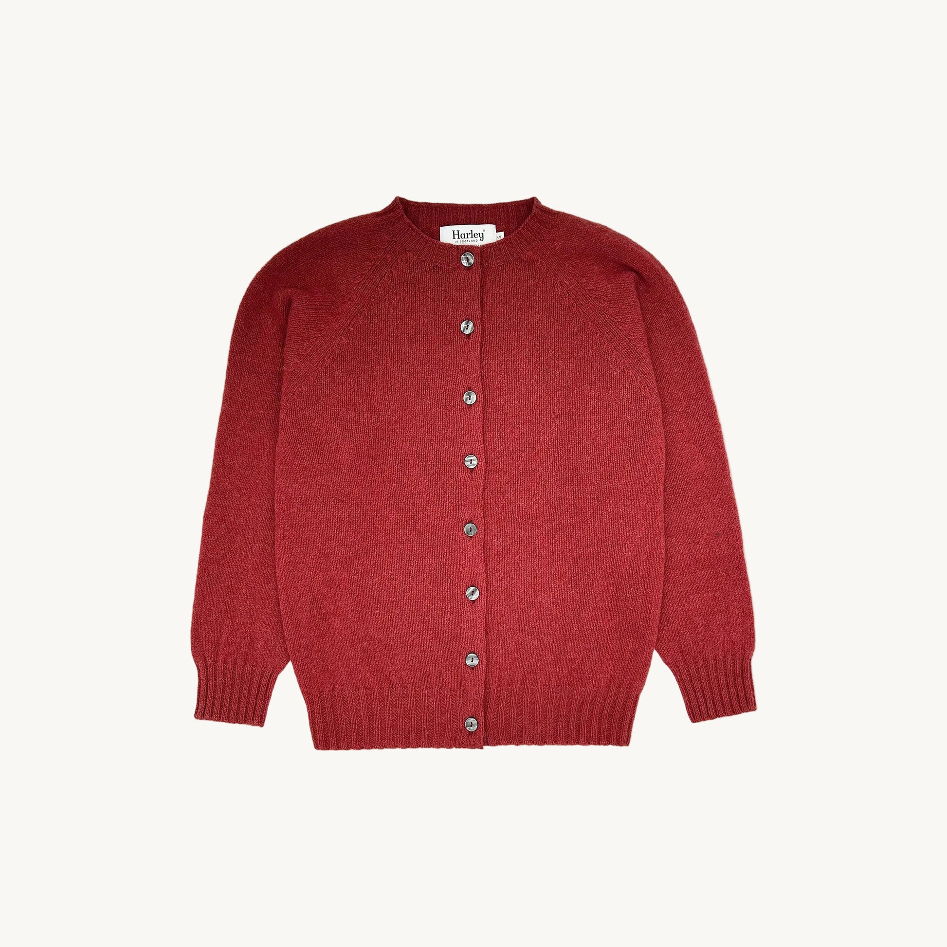 A flatbed photograph of a Bosie Womens Harley of Scotland Shetland Crew Neck Cardigan in colour Framboise.