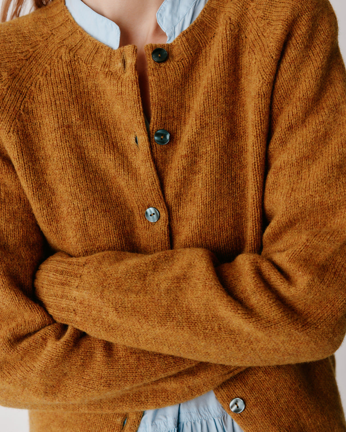 A model wearing a Bosie Womens Harley of Scotland Shetland Crew Neck Cardigan in colour Gold Dust / Cummin.