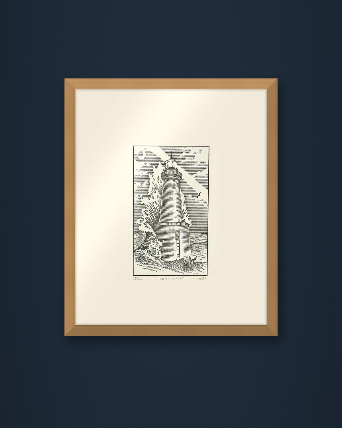 The Lighthouse: hand-pressed, hand-signed limited edition print of Nathan Yoder's hand-drawn illustration for Bosie Knitwear's Blue Mogganer collection, shown in an oak frame on a navy wall (frame not included)