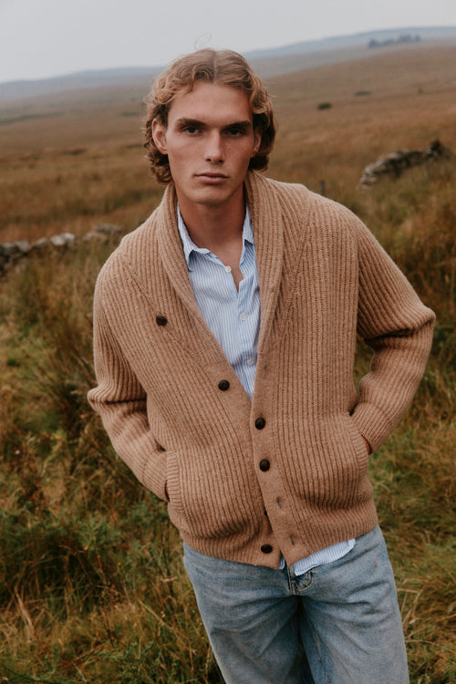 Man wearing the Bosie Blue Mogganer Harbourmaster chunky shawl cardigan in Sanday Camel from the Bosie Knitwear autumn/winter 2026 collection