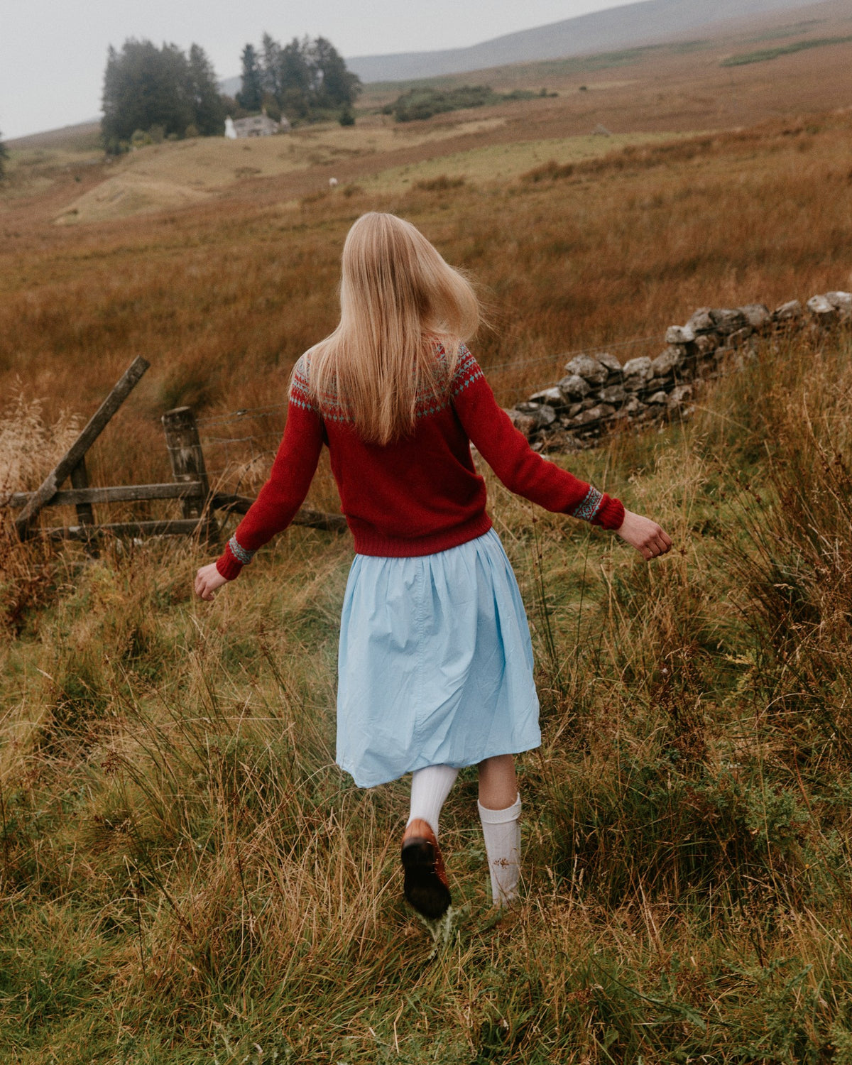 Model wearing the Bosie Hara Yoke Fair Isle Women's Sweater in French Red – seamless, seam-free pure wool, knitted in Scotland by Harley of Scotland for Bosie Knitwear