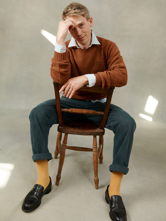 Man wearing a Bosie Knitwear Harley of Scotland seamless saddle shoulder men's Shetland sweater jumper in Sienna Brown