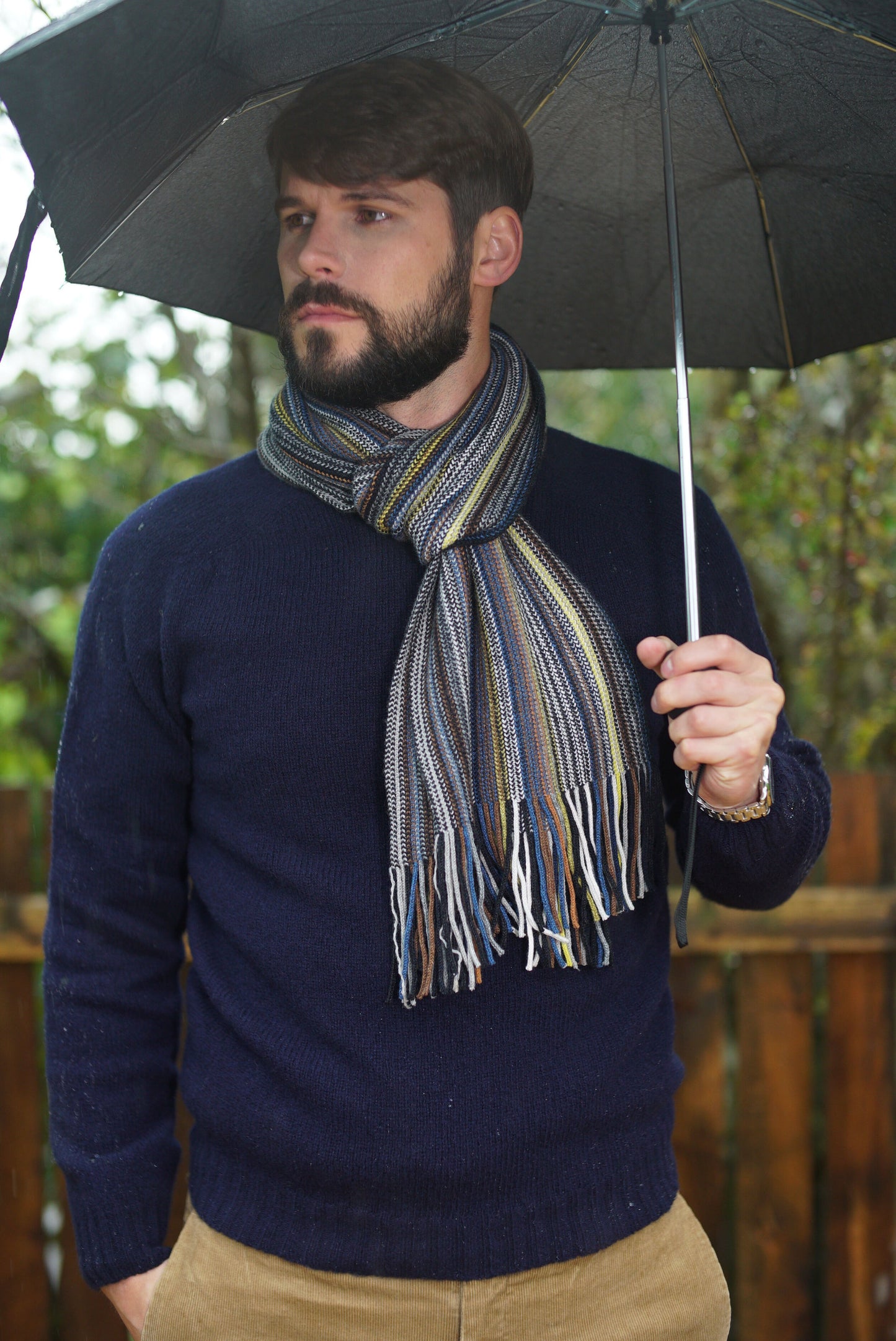 Man wearing a Harley of Scotland striped cashmere cotton striped scarf.