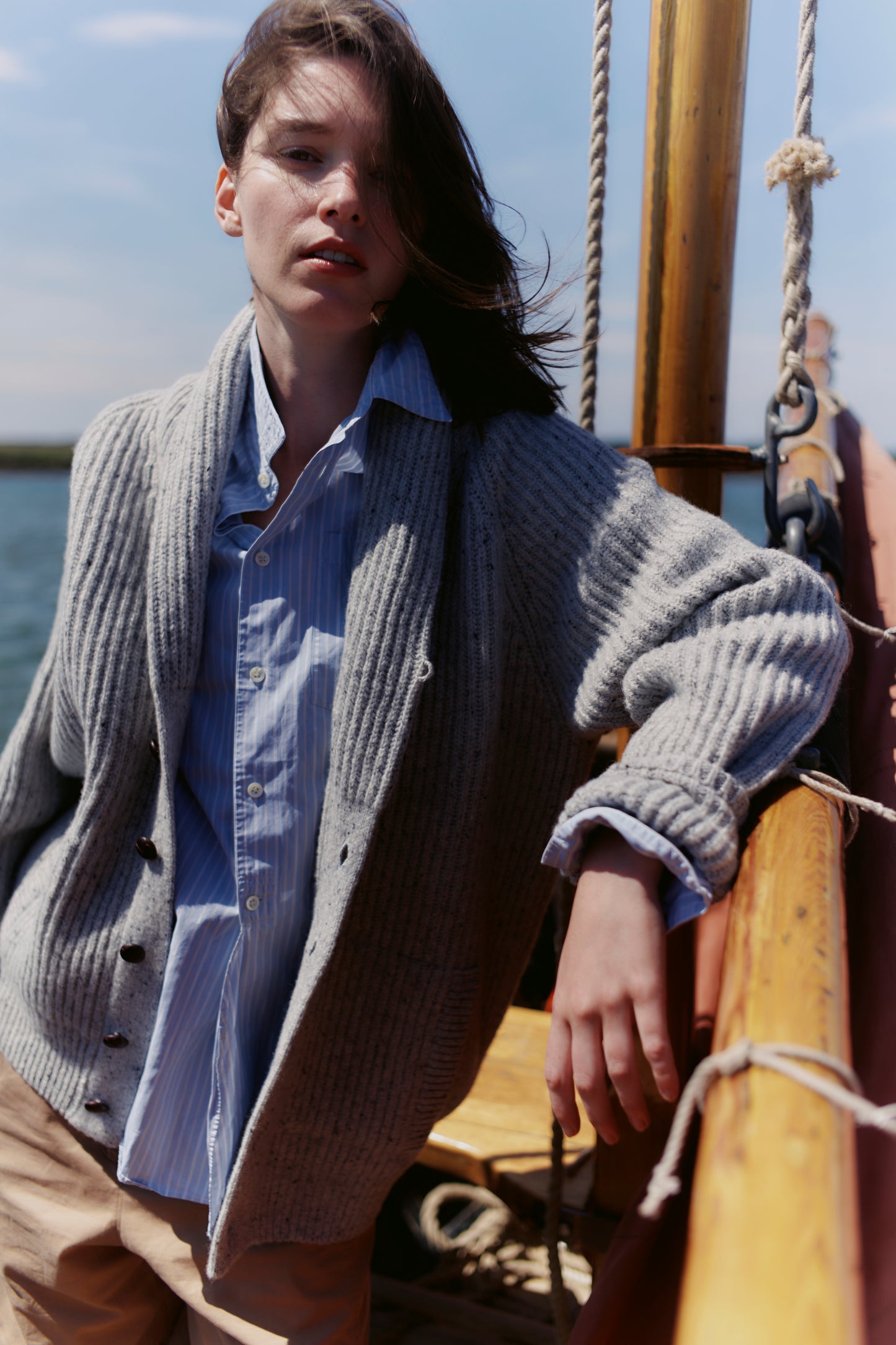 Woman on a boat wearing a Bosie Blue Mogganer Harbourmaster Cardigan and light blue shirt
