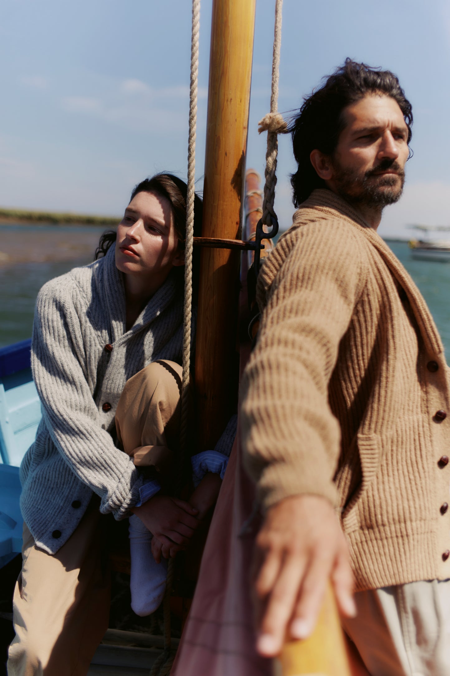 Man on boat wearing a Bosie Blue Mogganer Harbourmaster Cardigan in Sanday Camel