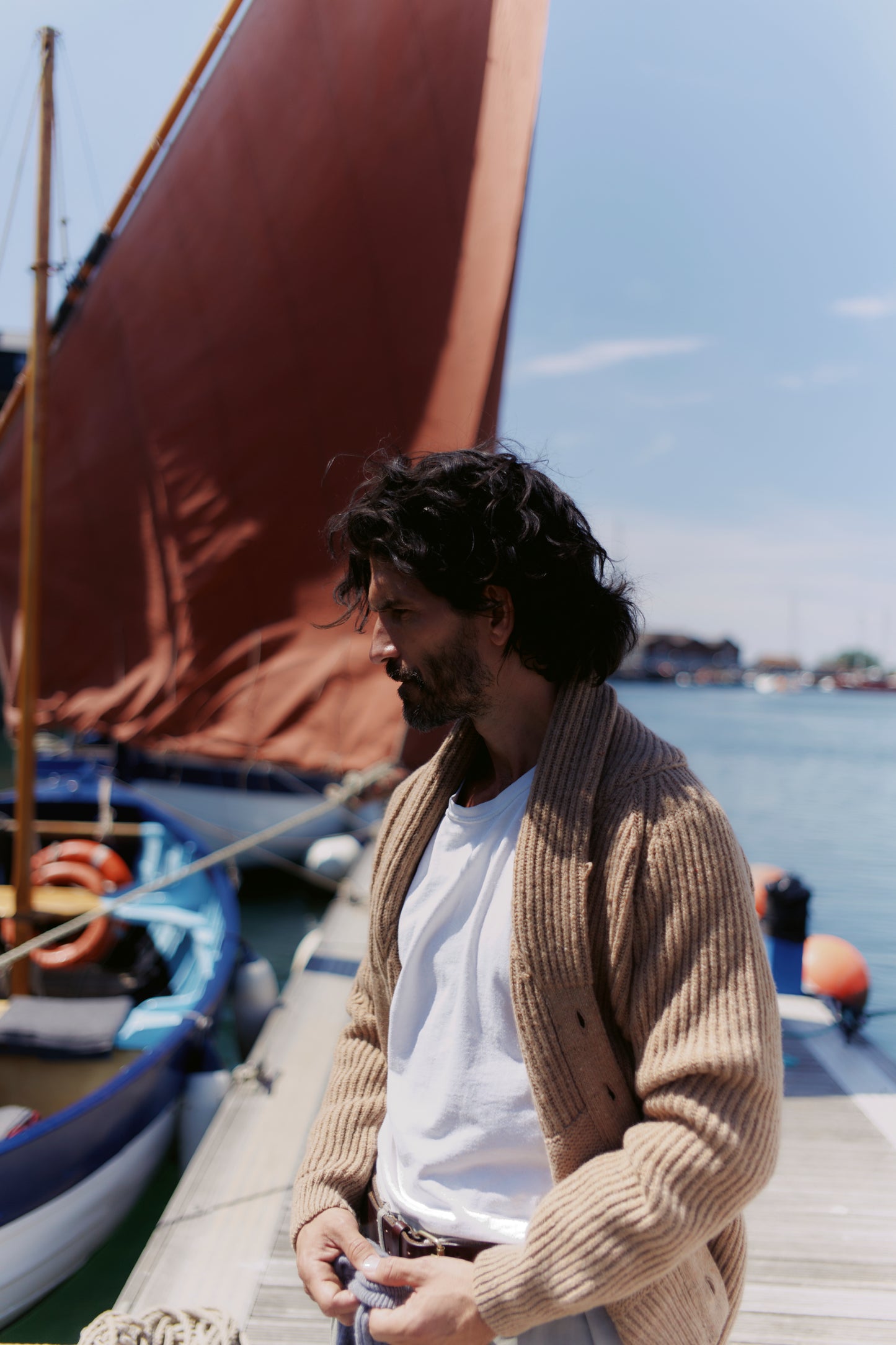 Man on boat wearing a Bosie Blue Mogganer Harbourmaster Cardigan in Sanday Camel