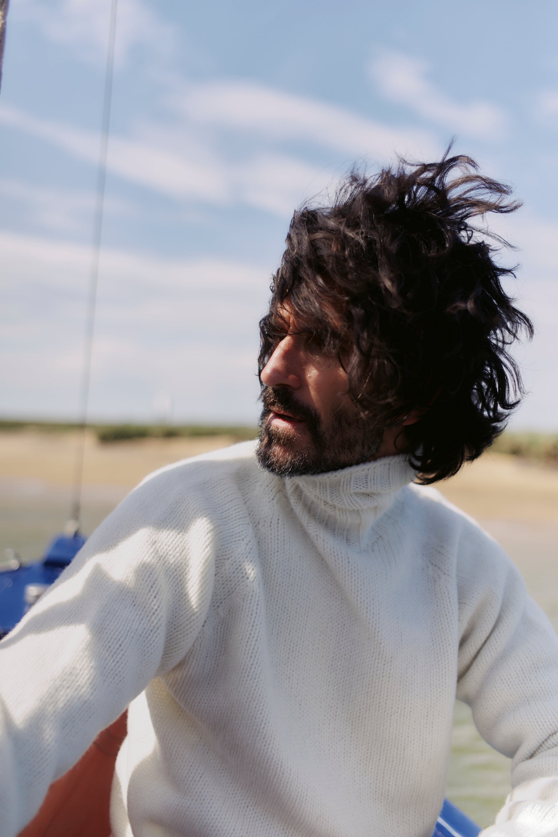 Man wearing a Blue Mogganer Submariner Polo Neck Shetland Chunky Sweater in Winter White by Bosie Knitwear